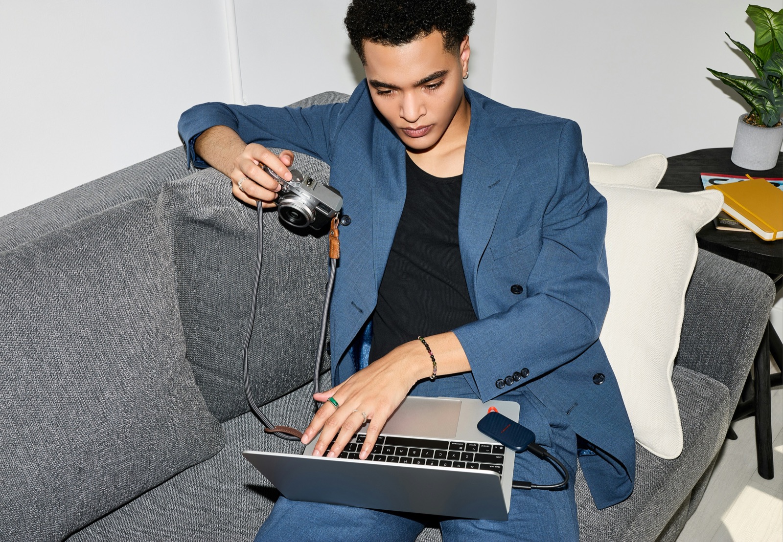 A creator working with a camera, laptop, and portable storage drive